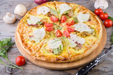 Bütün tavuk pizza ahşap bir masa üzerinde