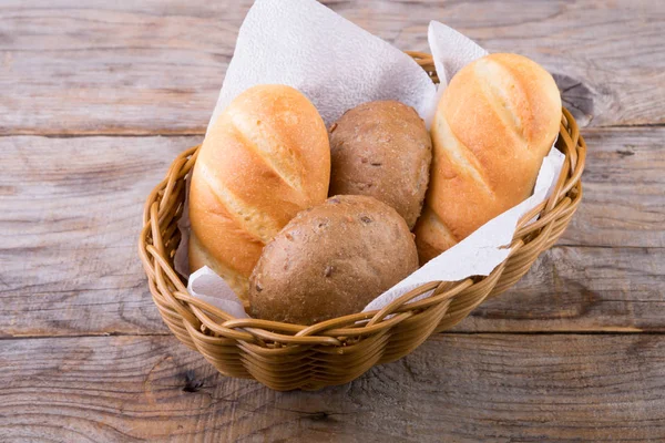 Cesta de pão em uma tábua de madeira — Fotografia de Stock