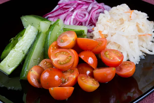 Légumes marinés sur une assiette noire — Photo