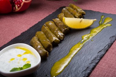 Yoğurt sosu ve limonla servis edilen Dolma ekmekleri.