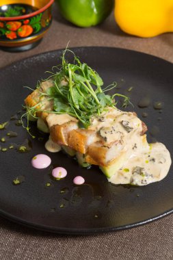 Salatalık ve sosla servis edilen yağlı kızarmış et.