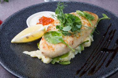 Havyar ve patates püresiyle servis edilen beyaz balık pirzolası.