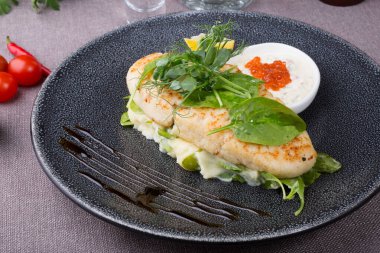 Havyar ve patates püresiyle servis edilen beyaz balık pirzolası.