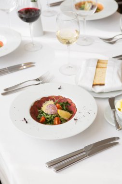 Bir restoranda servis edilen çiğ et jambonlu salata.