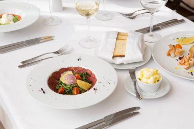 Bir restoranda servis edilen çiğ et jambonlu salata.