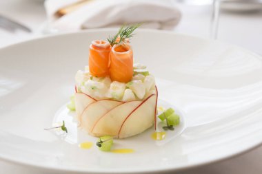 Beyaz kasede servis edilen zarif tütsülenmiş somon salatası.