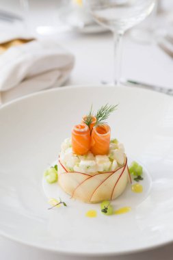 Beyaz kasede servis edilen zarif tütsülenmiş somon salatası.