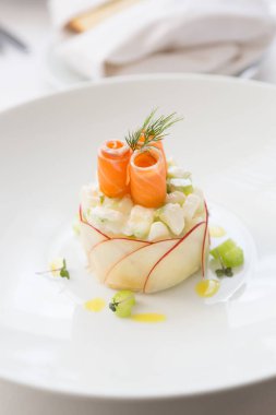 Beyaz kasede servis edilen zarif tütsülenmiş somon salatası.