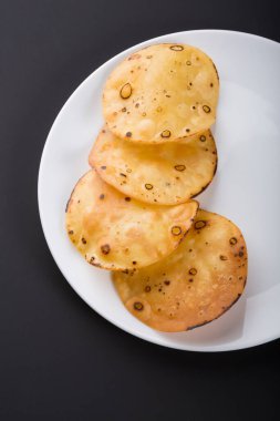 Beyaz tabakta sarı yuvarlak patates cipsi