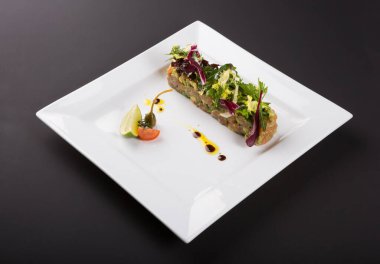 Taze somon tartı, salata ve limonla servis edilir.