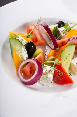 Beyaz tabakta servis edilen zarif sebze Yunan salatası
