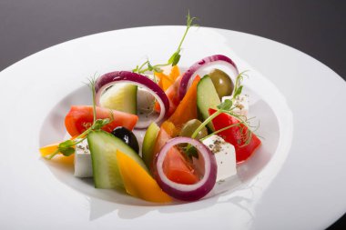 Beyaz tabakta servis edilen zarif sebze Yunan salatası