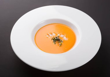 Karidesli turuncu balkabağı çorbası ve mikro yeşille süslenmiş.