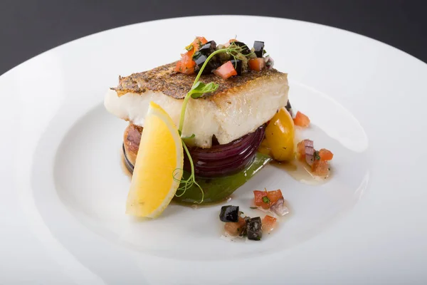 Prepared white fish fillet served with grilled vegetables