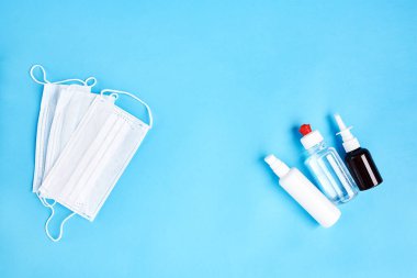 Koronavirüsü önle. Mavi arka planda tıbbi koruyucu maskeler var. Tek kullanımlık yüz maskesi ağız ve burnu kapatır. Sağlık sigortası Coronavirus karantinası, hijyen konsepti