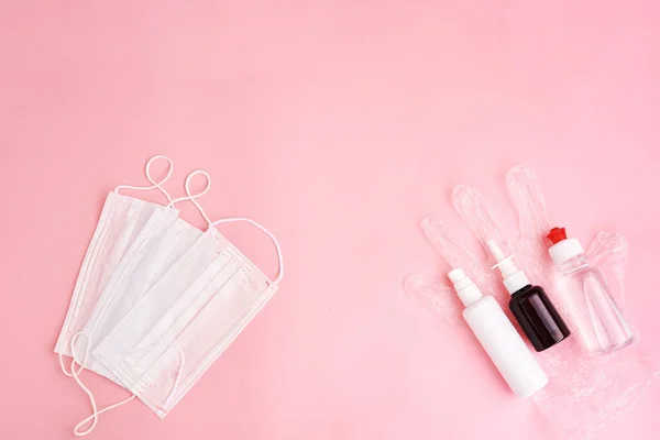 Medical protective mask and antiseptic bottles on transparent gloves isolated on pink background. Healthcare medical Coronavirus quarantine — Stock Photo, Image