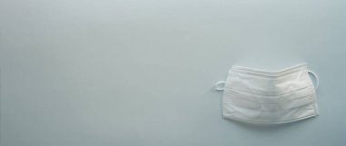 Açık mavi arka planda izole edilmiş beyaz cerrahi maske. panoramik biçim