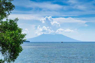 Deniz ve Java volkanı güneşli bir günde beyaz bulutlarla