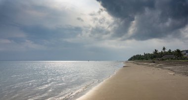 Tropik bir plajın deniz manzarası. Işıklı ve bulutlu muhteşem gökyüzü