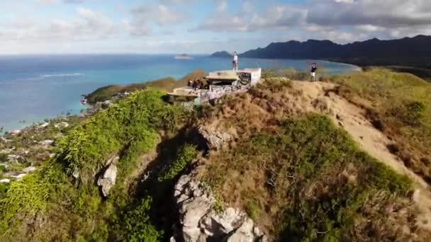 位于美国夏威夷瓦胡岛Lanikai Pillbox的山地和海岸线上的一对情侣的4K无人驾驶飞机镜头 低角度倾斜运动 — 图库视频影像