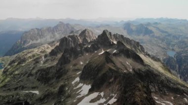 Pireneler 'deki Besiberris bölgesinde az kar bulunan dağların 4K insansız hava aracı görüntüleri. Orta açı, parallax hareketi.