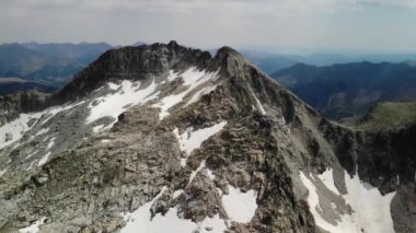 Pireneler 'deki Besiberris bölgesinde çok az kar bulunan dağ sırtının 4K drone görüntüleri. Orta açı, parallax hareketi.