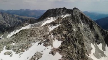 Pireneler 'deki Besiberris bölgesinde çok az kar bulunan dağ sırtının 4K drone görüntüleri. Orta açı, seyahat hareketi.
