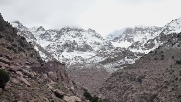 在Toubkal的小房子里 带着摩洛哥地图集的徒步旅行在后面堆满了雪 高角慢动作高清 — 图库视频影像