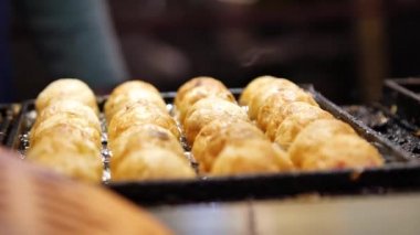 Tayvan 'daki Shilin Night Market' te peynirli patates köftesi pişiriliyor. Tayvan sokak yemekleri. Düşük açı, parallax hareketi, yavaş çekim, HD.