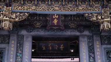 Çin dekorasyon çatıları Longshan Tapınağı girişinin üzerinde Çince yazılar, Taipei, Tayvan. Yüksek açı, statik hareket, yavaş çekim, HD.