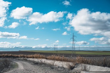 Kuru samanla sonbaharda tarla manzarası. elektrik kulesi