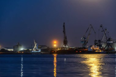Ticari bir gemi ve Vinçler gece limanda