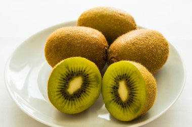 Beyaz bir tabakta kivi kes