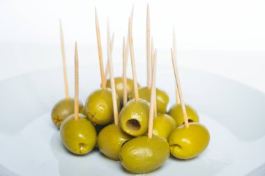 Beyaz tabakta kürdanlı yeşil zeytin.