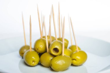 Beyaz tabakta kürdanlı yeşil zeytin.