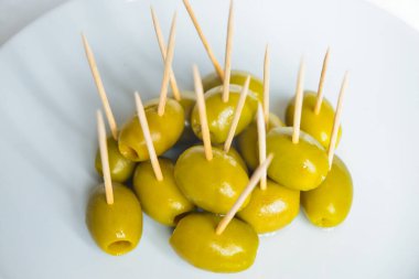 Beyaz tabakta kürdanlı yeşil zeytin.