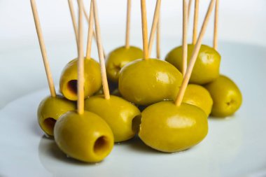 Beyaz tabakta kürdanlı yeşil zeytin.