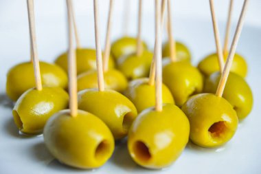 Beyaz tabakta kürdanlı yeşil zeytin.