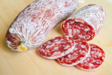 Tahta kesme tahtasında dilimlenmiş salam.