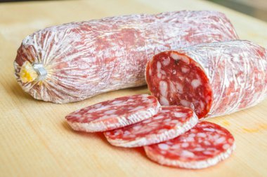 Tahta kesme tahtasında dilimlenmiş salam.