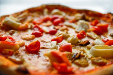 Çeri domatesli, deniz ürünleri ve mantarlı taze pişmiş pizza.