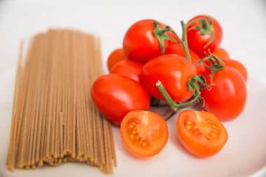 Beyaz tabakta domates ve spagetti kes.