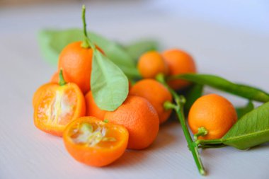 Olgun kalamondinleri ahşap bir masada kesiyor.