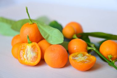 Olgun kalamondinleri ahşap bir masada kesiyor.