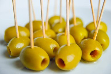 Beyaz tabakta kürdanlı yeşil zeytin