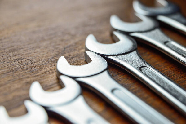 Metallic wrenches on wooden surface