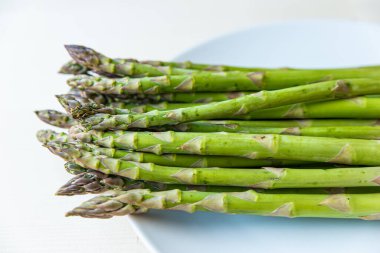 Taze toplanmış kuşkonmaz, beyaz bir tabağa koy.