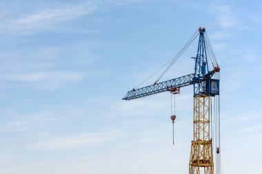 Mavi gökyüzüne karşı bir inşaat alanında kule vinci