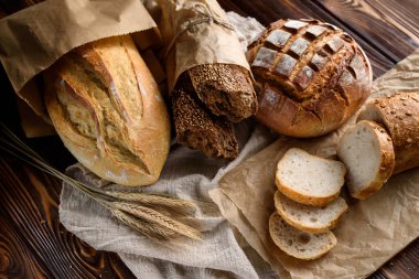 Ahşap bir kırsal masada çeşitli taze pişmiş ekmek.