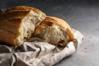 Taze pişmiş taze kokulu ekmek. Gri arka planda iki parçaya ayrılmış.